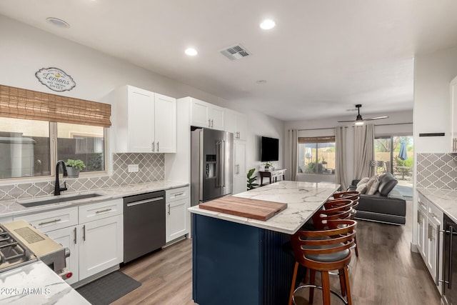 40807 N Barnum Way, Anthem, AZ 85086 - kitchen featuring stainless steel appliances, a sink, open floor plan, a kitchen island, and tasteful backsplash