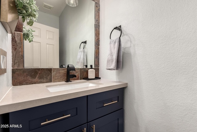 40807 N Barnum Way, Anthem, AZ 85086 - bathroom with vanity, a textured wall, and tasteful backsplash