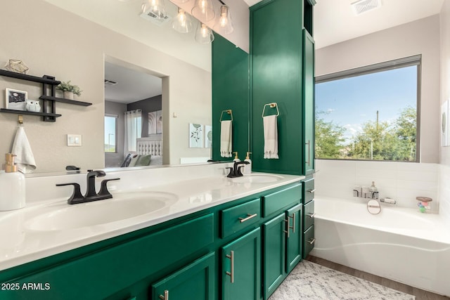40807 N Barnum Way, Anthem, AZ 85086 - bathroom featuring ensuite bathroom, double vanity, a bath, and wood finished floors