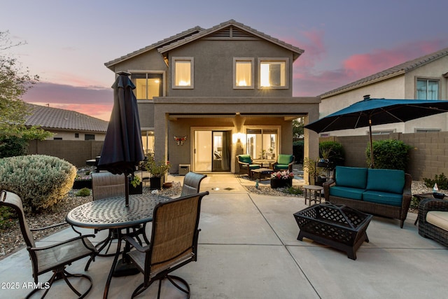 40807 N Barnum Way, Anthem, AZ 85086 - back of property at dusk featuring an outdoor living space with a fire pit, a patio, stucco siding, a fenced backyard, and outdoor dining area