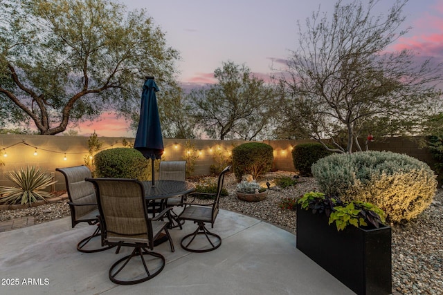 40807 N Barnum Way, Anthem, AZ 85086 - patio terrace at dusk featuring outdoor dining area, a patio area, and a fenced backyard