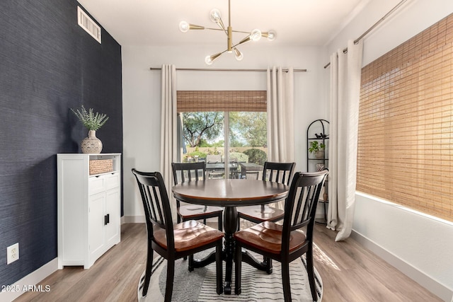 40807 N Barnum Way, Anthem, AZ 85086 - dining area featuring a chandelier, light wood finished floors, baseboards, and an accent wall