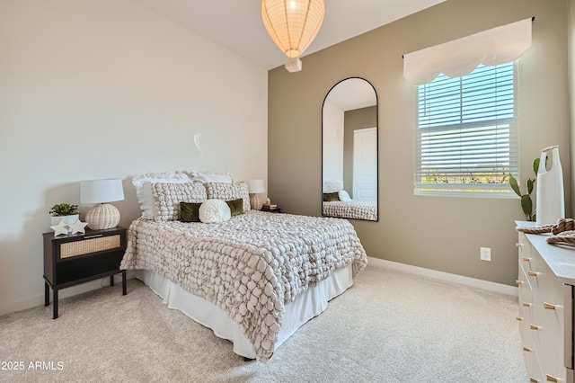 bedroom featuring arched walkways, light carpet, and baseboards