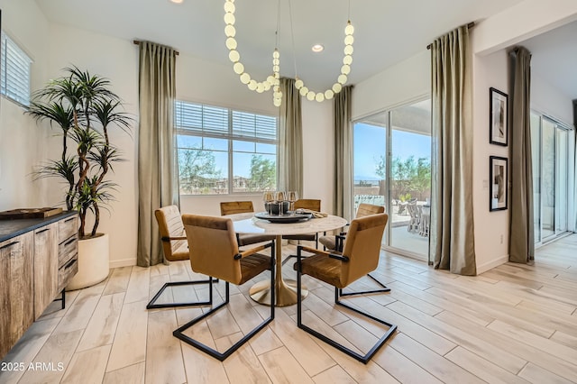 dining space featuring light wood finished floors, baseboards, and recessed lighting