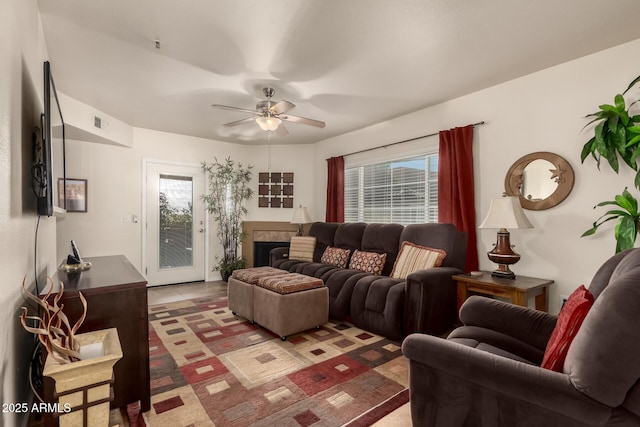 living room with ceiling fan, plenty of natural light, and light tile patterned floors