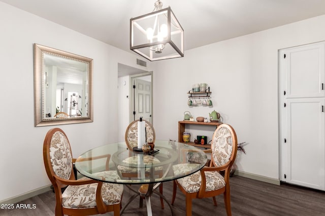 dining room featuring visible vents, baseboards, an inviting chandelier, and dark wood finished floors