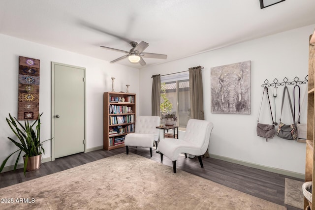 living area featuring wood finished floors, ceiling fan, and baseboards
