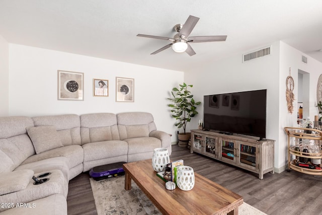 living area with visible vents, ceiling fan, wood finished floors, and baseboards