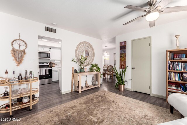 sitting room featuring dark wood-type flooring, baseboards, a ceiling fan, and visible vents