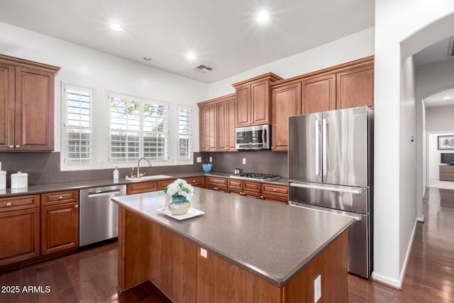 kitchen featuring sink, tasteful backsplash, a center island, dark hardwood / wood-style flooring, and stainless steel appliances