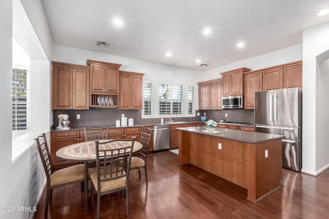 kitchen with tasteful backsplash, stainless steel appliances, sink, and a kitchen island