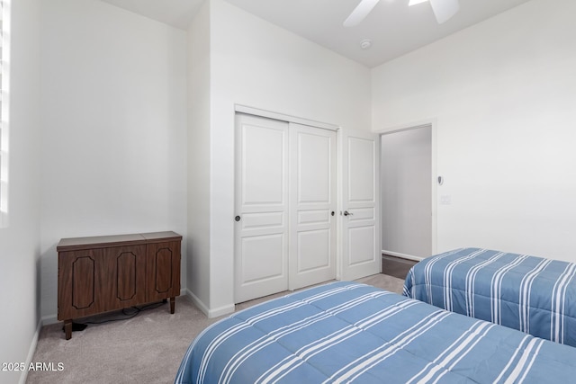 bedroom featuring ceiling fan, a closet, and light carpet