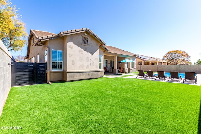 rear view of property with a yard and a patio