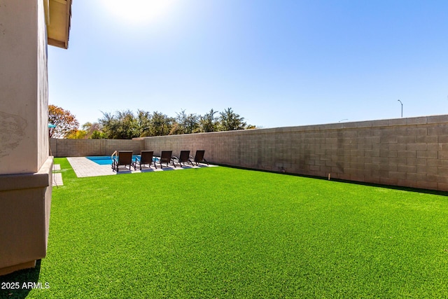 view of yard with a fenced in pool and a patio