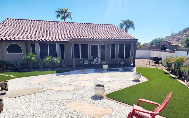 rear view of house with a patio, a lawn, and a sunroom