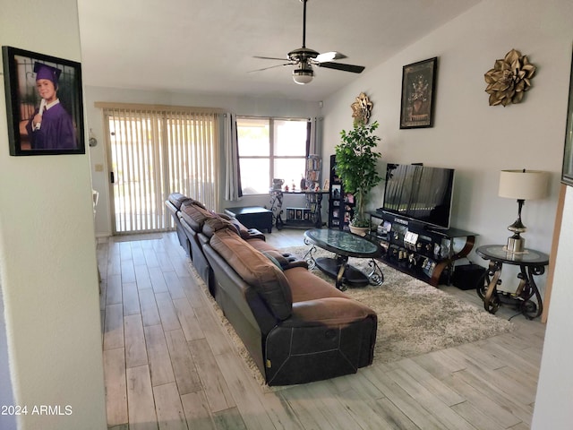 living room with ceiling fan, vaulted ceiling, and light hardwood / wood-style floors