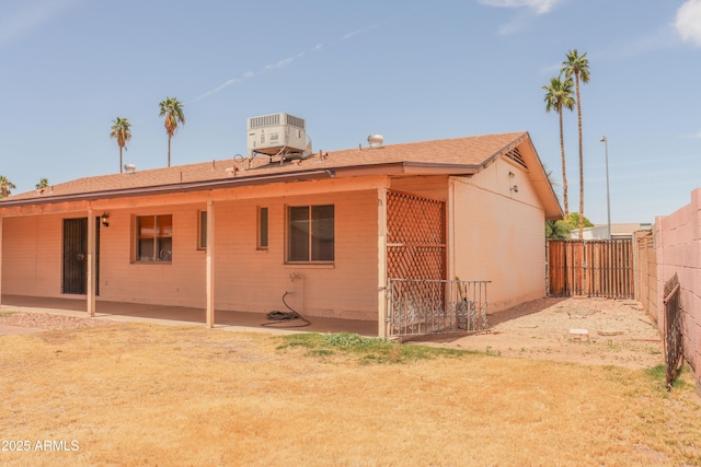 rear view of property with a patio, a fenced backyard, and central AC unit