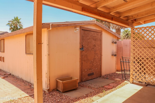 view of shed with fence and a gate