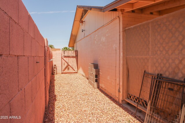 view of home's exterior featuring fence and concrete block siding