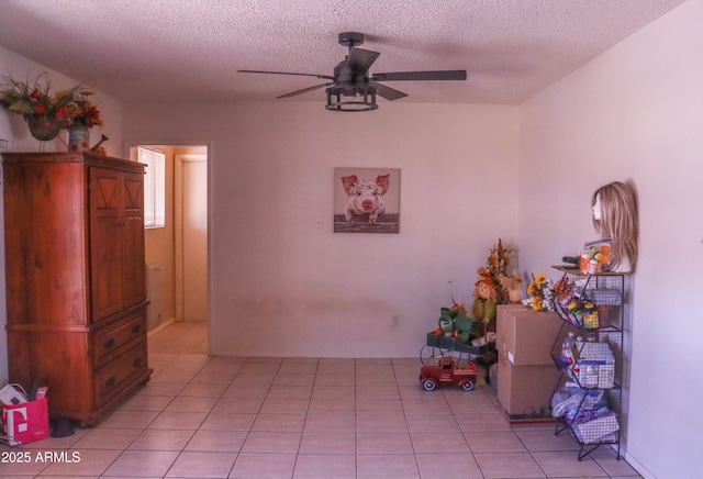 dining area featuring a textured ceiling, ceiling fan, and light tile patterned floors