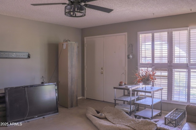 carpeted living room with a textured ceiling and ceiling fan
