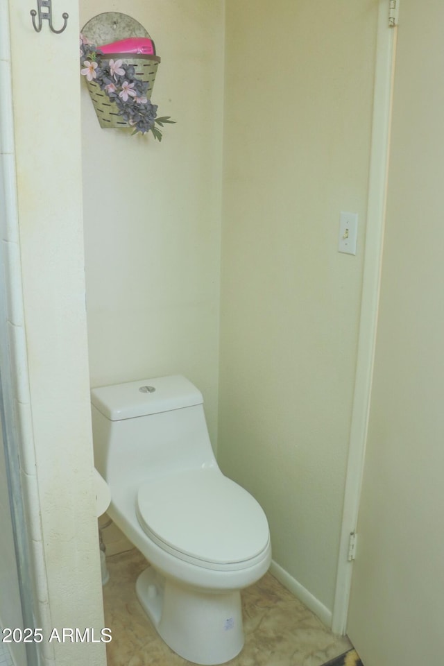 bathroom featuring toilet and baseboards