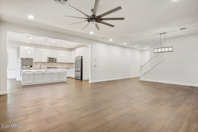 970 W Zion Way, Chandler, AZ 85248 - unfurnished living room featuring ceiling fan, recessed lighting, baseboards, light wood finished floors, and stairway