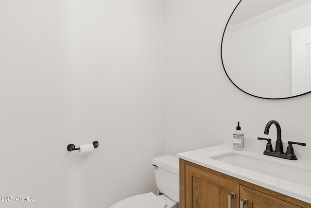 bathroom featuring toilet, ornamental molding, and vanity