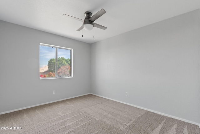 empty room featuring baseboards, a ceiling fan, and carpet flooring
