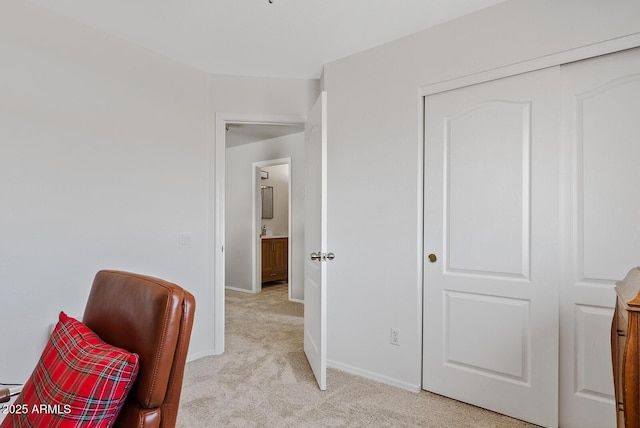 living area featuring light colored carpet and baseboards