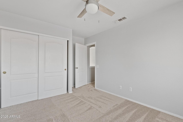 unfurnished bedroom with baseboards, visible vents, carpet, and a closet
