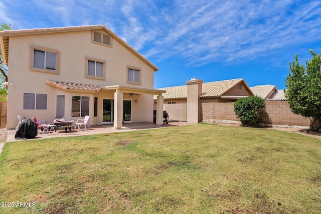 rear view of property with fence, stucco siding, and a yard