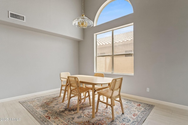 dining room featuring baseboards, visible vents, and an inviting chandelier