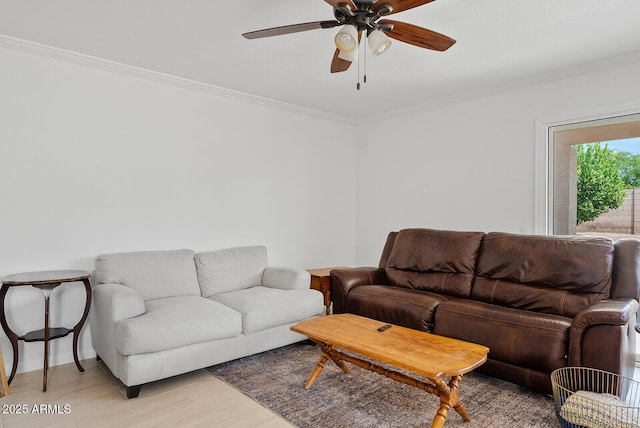 living area with crown molding, baseboards, a ceiling fan, and light wood-style flooring