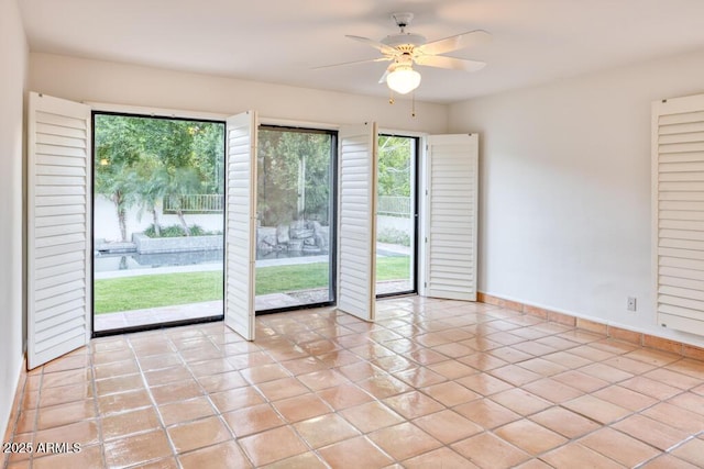 spare room with ceiling fan and light tile patterned floors