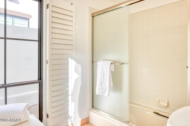 bathroom featuring bath / shower combo with glass door