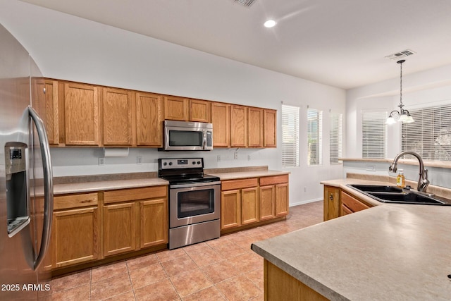 3553 W Dancer Ln, San Tan Valley, AZ 85144 - kitchen featuring stainless steel appliances, light tile patterned flooring, decorative light fixtures, brown cabinetry, and recessed lighting