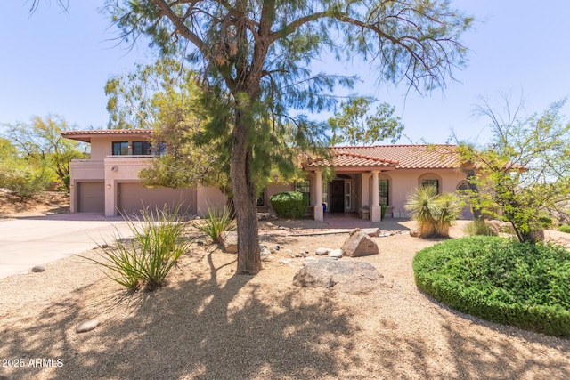 1305 Coyote Pass, Carefree, AZ 85377 - mediterranean / spanish-style house featuring concrete driveway, a tile roof, a garage, and stucco siding