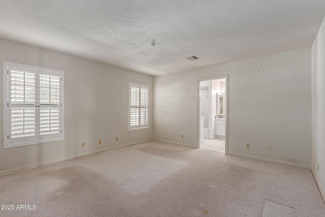 1305 Coyote Pass, Carefree, AZ 85377 - carpeted empty room with a textured ceiling, a healthy amount of sunlight, baseboards, and visible vents