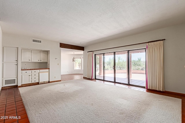 1305 Coyote Pass, Carefree, AZ 85377 - unfurnished living room featuring a textured ceiling, baseboards, visible vents, and a notable chandelier