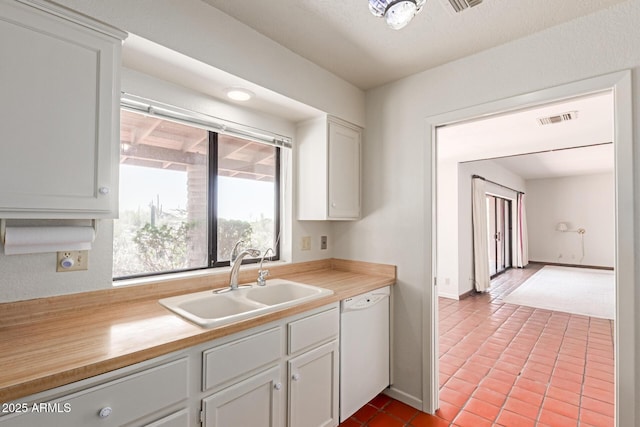 1305 Coyote Pass, Carefree, AZ 85377 - kitchen with tile patterned flooring, white cabinets, visible vents, white dishwasher, and a sink
