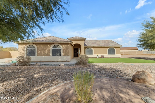 mediterranean / spanish-style home featuring a front yard