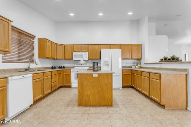 kitchen with sink, light tile patterned floors, a kitchen island, a towering ceiling, and white appliances