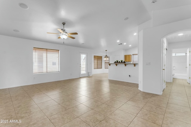 unfurnished living room featuring ceiling fan, vaulted ceiling, and light tile patterned floors