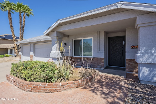 5944 W Greenbriar Dr, Glendale, AZ 85308 - doorway to property with an attached garage, driveway, and stucco siding