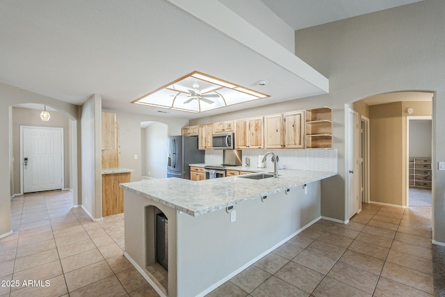 5944 W Greenbriar Dr, Glendale, AZ 85308 - kitchen with arched walkways, appliances with stainless steel finishes, open shelves, and a sink