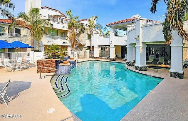 view of swimming pool with a patio area and french doors