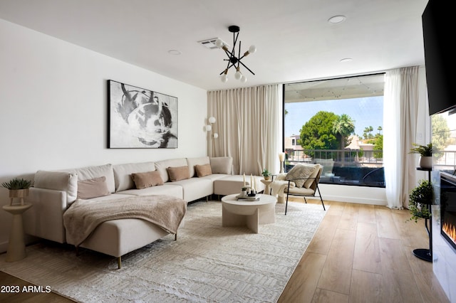 living room with a chandelier and light wood-type flooring