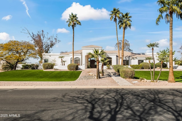 mediterranean / spanish-style house featuring stucco siding and a front yard