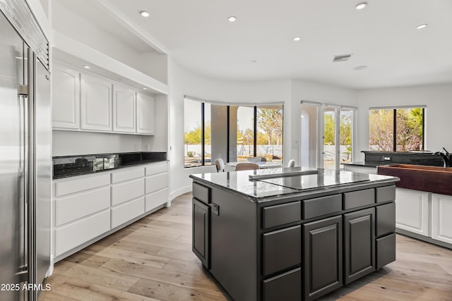 kitchen with visible vents, open floor plan, stainless steel built in refrigerator, and white cabinetry